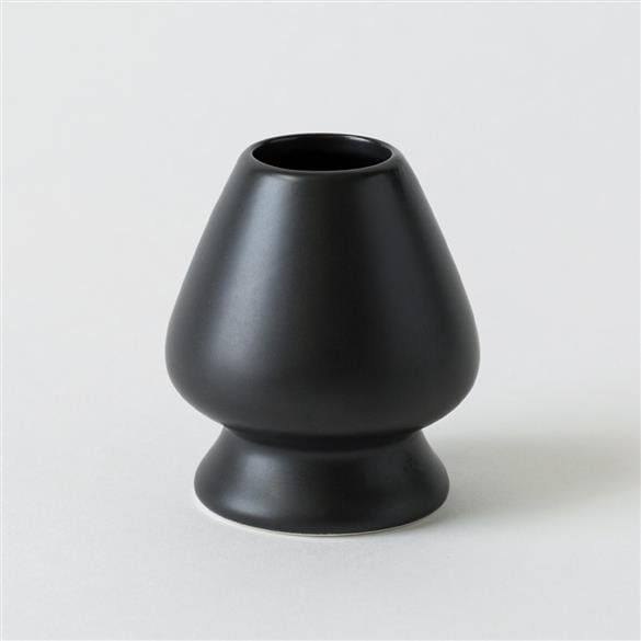 A Chasen Matcha Whisk Stand from Rishi Tea & Botanicals sitting on a white surface.