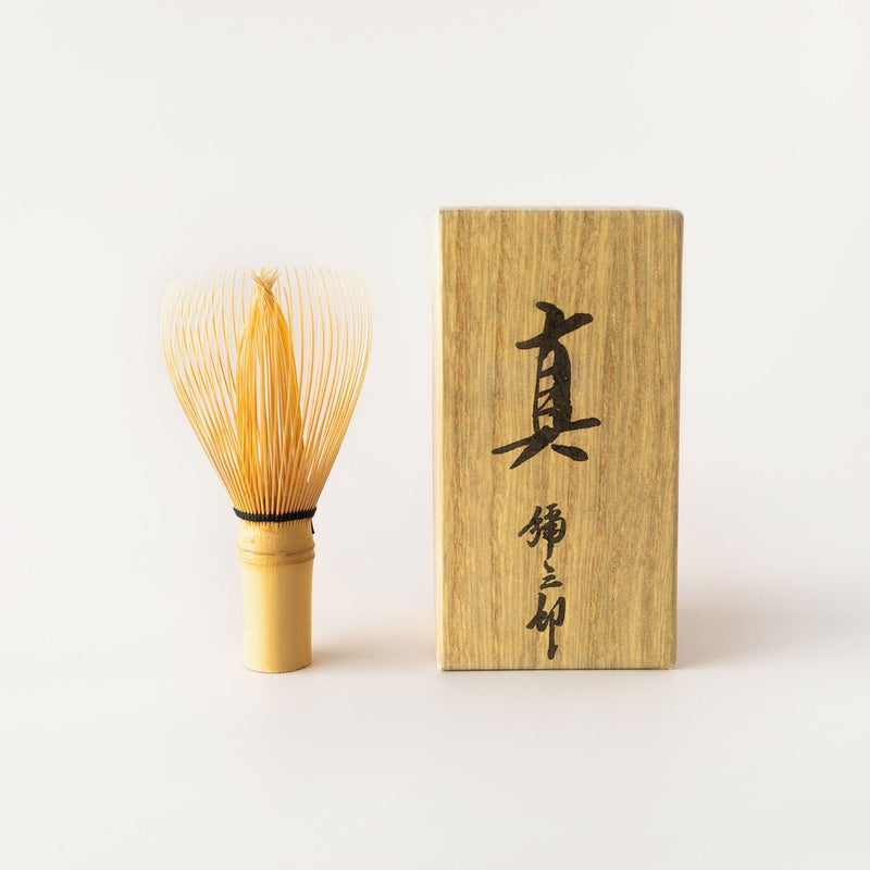 A premium Shin Chasen by Rishi Tea & Botanicals with a wooden box next to it, known for being flexible and resistant to breakage.