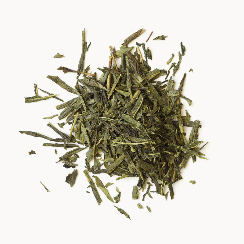 A pile of Rishi Tea & Botanicals Bancha leaves on a white background.