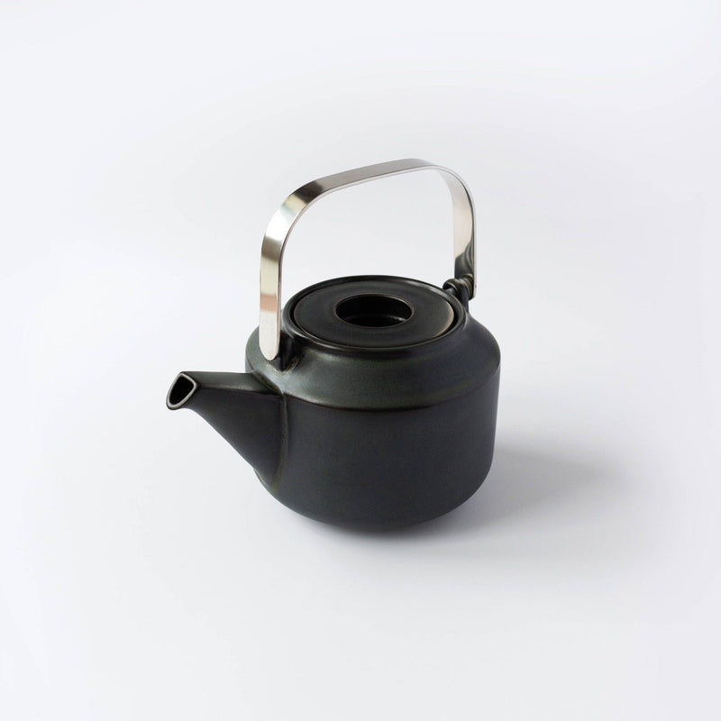 Kinto USA, Inc's black teapot with a metal handle rests on a light gray background, highlighting the elegant simplicity of Japanese craftsmanship.