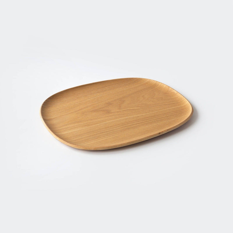 A rectangular wooden plate with rounded edges, crafted by Kinto USA from natural willow plywood, rests on a plain white background.